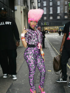 Nicki Minaj wearing a purple and pink pansuit and a pink wig
